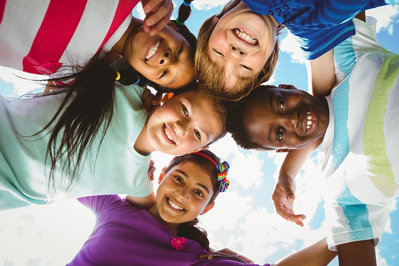 Diverse children posing looking down at the camera